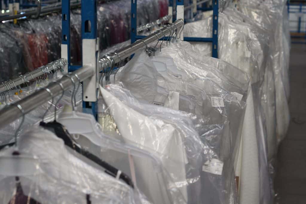 Garments stored on a rail in a warehouse