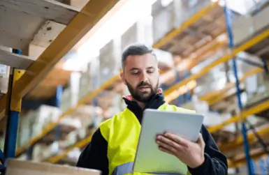 Man checking clipboard in warehouse
